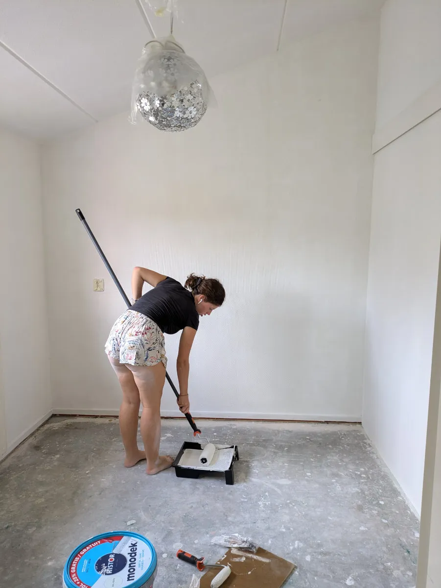 Gemma is using the roller to paint.