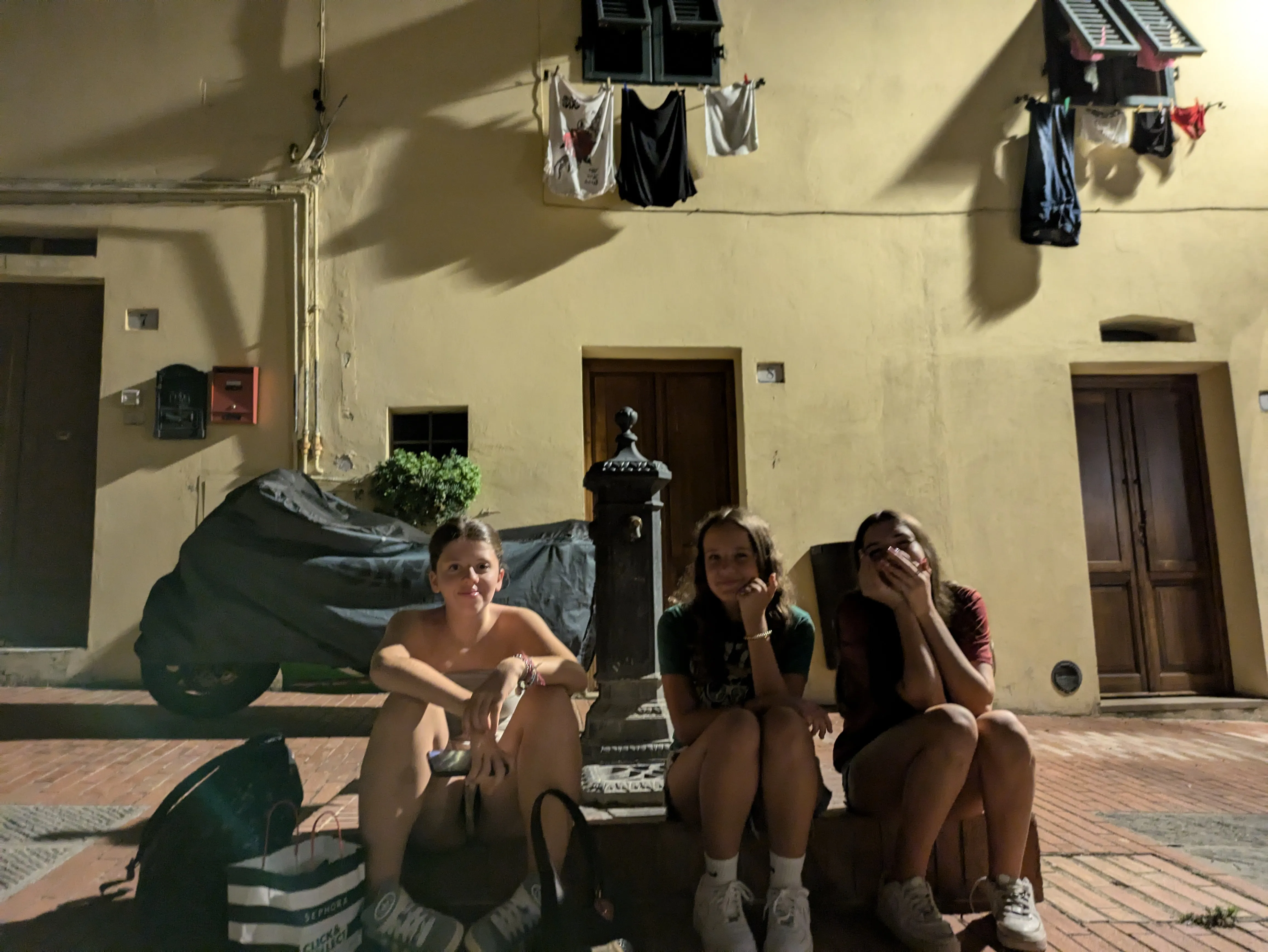 Gemma and her friends sitting in the small square of Montaione.