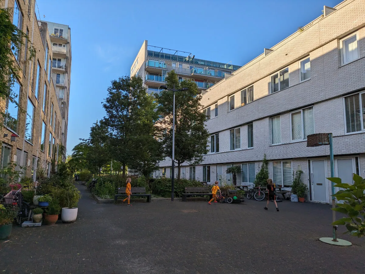 Children playing soccer between the houses